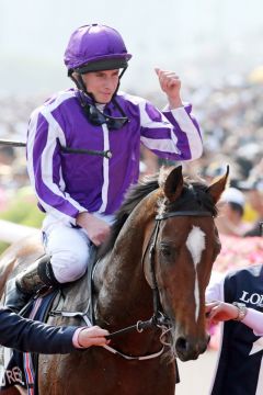 Ryan Moore feiert seinen Erfolg mit Highland Reel. www.galoppfoto.de