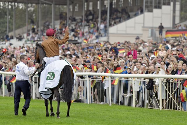 Lord Charming and the packed grandstand in Hoppegarten. www.galoppfoto.de