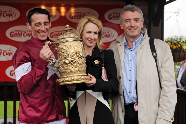 Hat sein Portfolio im Galopprennsport erweitert: Ryan Air-Eigner Michael O'Leary (rechts) - hier mit Ehefrau und Jockey Davy Russell bei der Siegerehrung zum Punchestown Gold Cup. www.galoppfoto.de - John James Clark