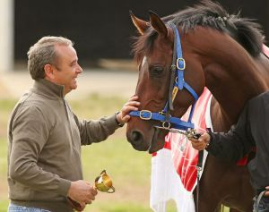 Mit der kleinen Ausgabe des Melbourne Cups in der Hand nimmt Trainer Andreas Wöhler Abschied von seinem Star-Galopper