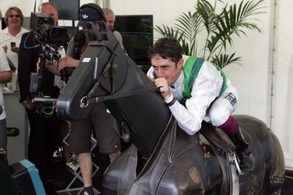 Auf dem German Tote-Stand: Jockey Christophe Soumillon macht sich vor dem Derby auf dem elektrischen Pferd warm. www.galoppfoto.de - Frank Sorge