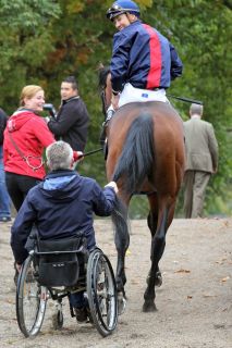 Nach dem Sieg: Trainer Christian Zschache hält sich an Gepards Schweif fest, um sich ziehen zu lassen. www.galoppfoto.de - Sabine Brose